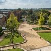 Aerial view of campus buildings, trees and courtyard area on a sunny day.