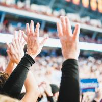 Audience members with their hands up at an American political rally