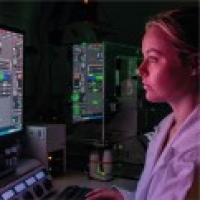 biomedical science student looking at a computer in a dark room