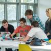 College students huddled around laptop for a group task