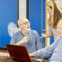 2 men using a laptop together