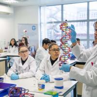 School children in lab coats learning in the Life Lab.