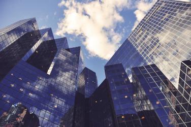 Low-angle view of city office buildings reflecting the sky