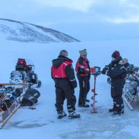 A team of scientists with equipment carrying out field research on a glacier