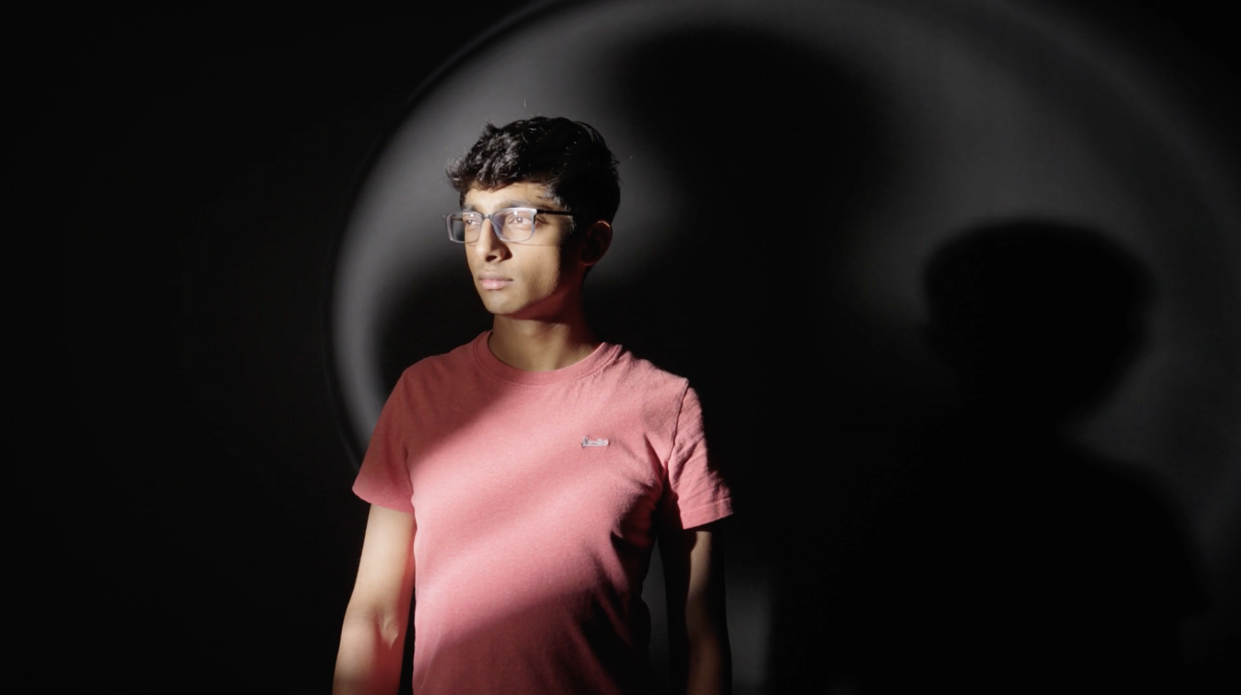 A student stood in the shadow of a large turbine blade.