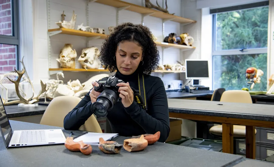 Archaeology student recording roman oil lamps in the lab