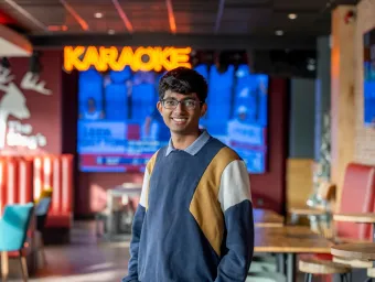 A student stood smiling in a students' union bar.