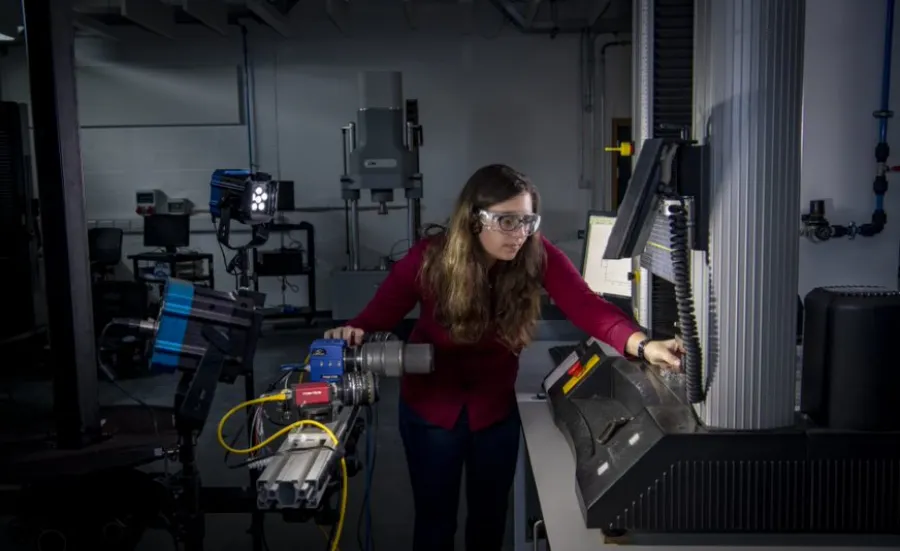 A student uses a piece of equipment in the testing and structures research lab