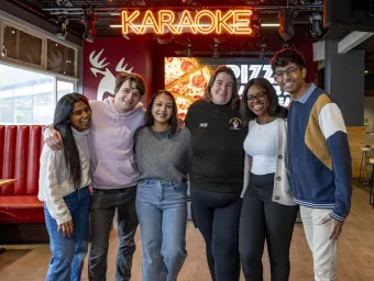 A group of students stood smiling in a students' union bar.